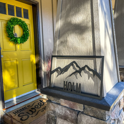 metal sign custom name - Holm with mountains mounted next to yellow door - by motomattick designs and LeeMo Designs in Bend Oregon