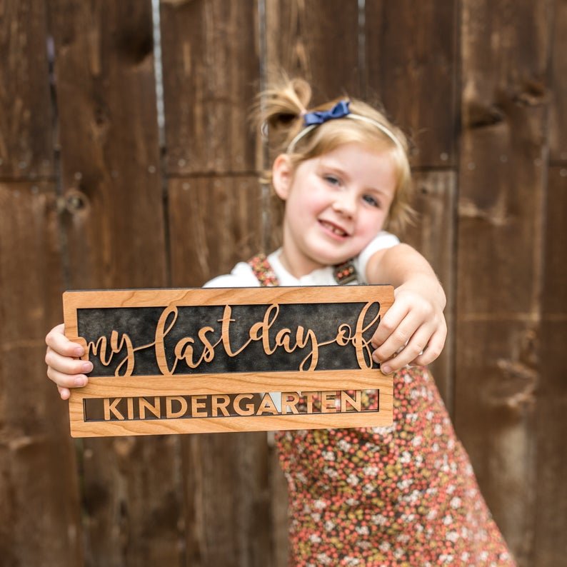 Reusable back-to-school wood sign - Cherry wood sign being held says "my last day of kindergarten" - By LeeMo Designs in Bend, Oregon