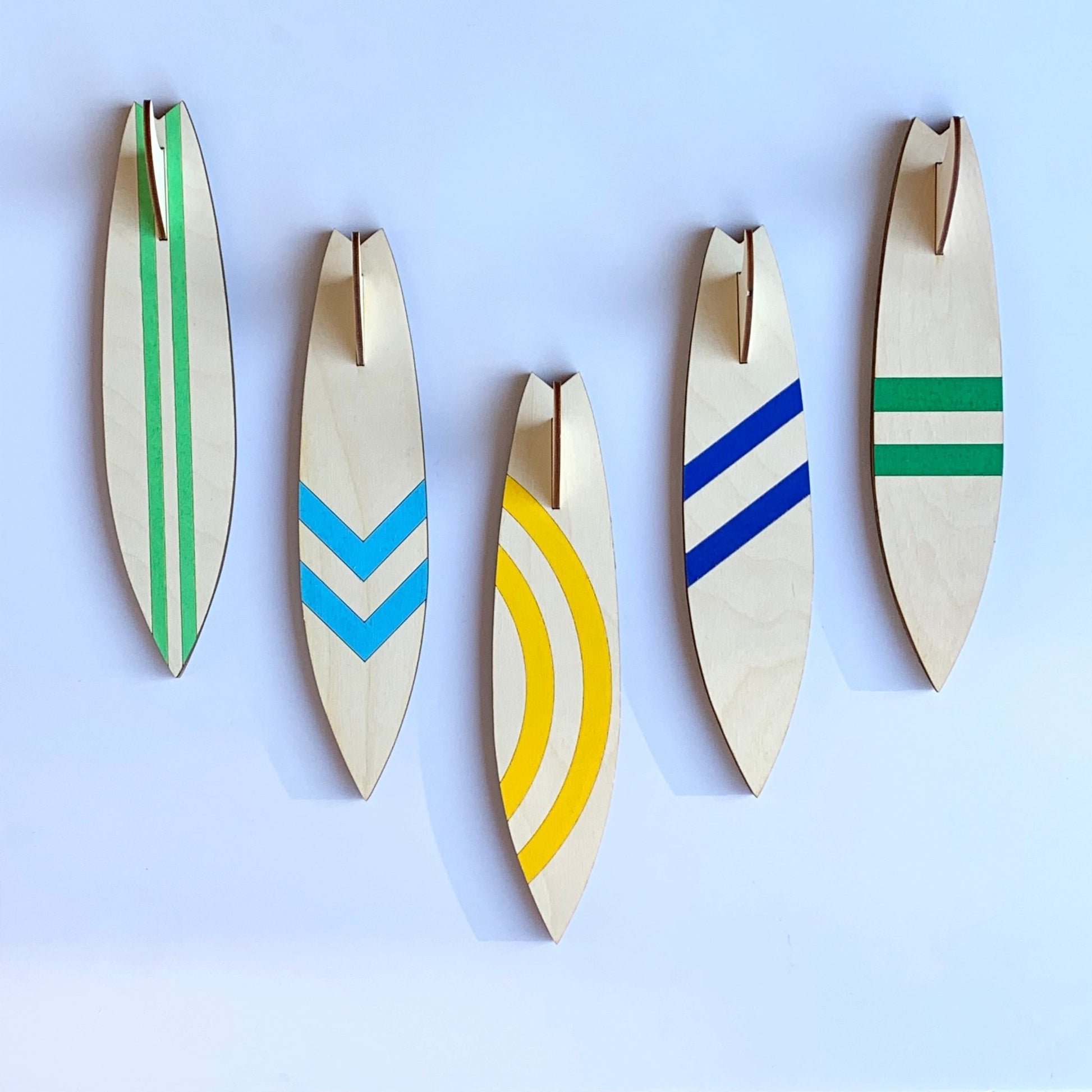 Surfboard Hooks - laser cut and laser engraved birch wood - light green vertical stripes, light blue chevron, yellow circular stripes, blue diagonal stripes, green horizontal stripes - by LeeMo Designs in Bend, Oregon